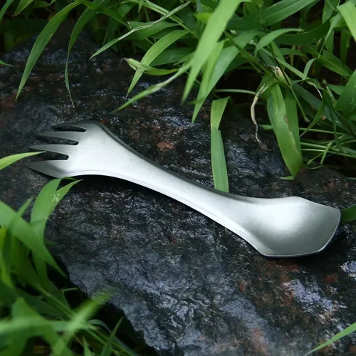 Göffel aus Titan auf einem Stein zwischen Gräsern