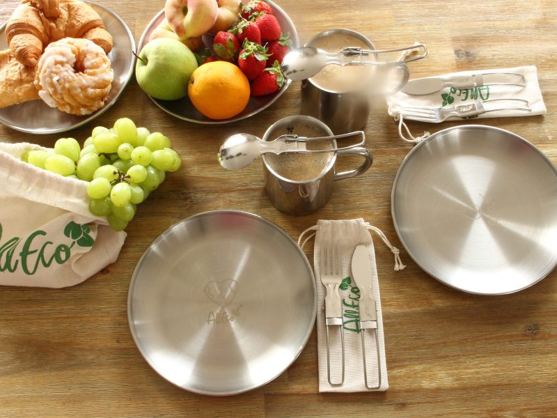 Gedeckter Frühstückstisch mit Edelstahltellern, Thermobechern und Camping-Besteck von AllEco