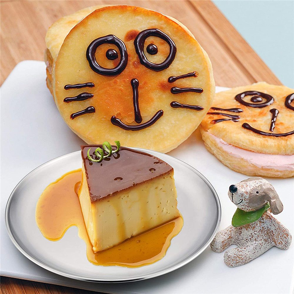 Pfannkuchen mit Katzengesicht und Pudding auf einem Edelstahlteller