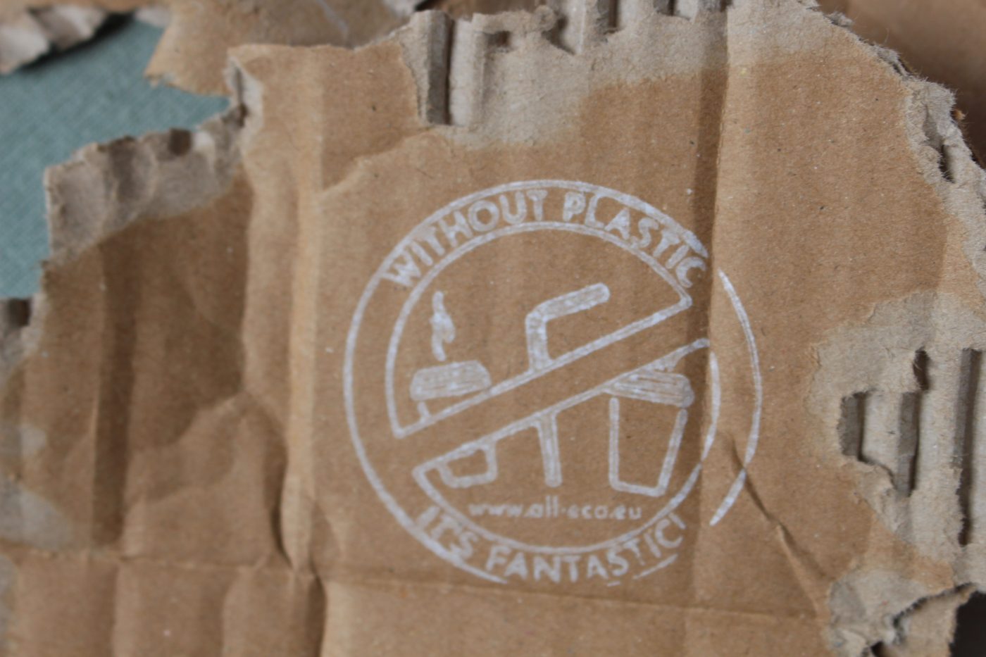 AllEco-Stempel „Without plastic – it's fantastic“ auf einem Stück Pappe